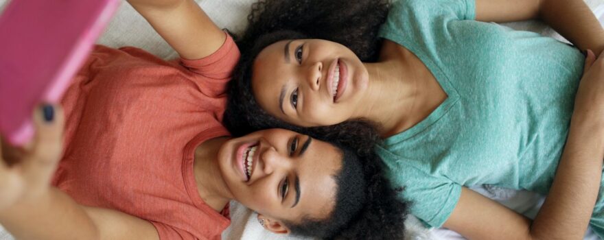 Teens Smiling on Bed